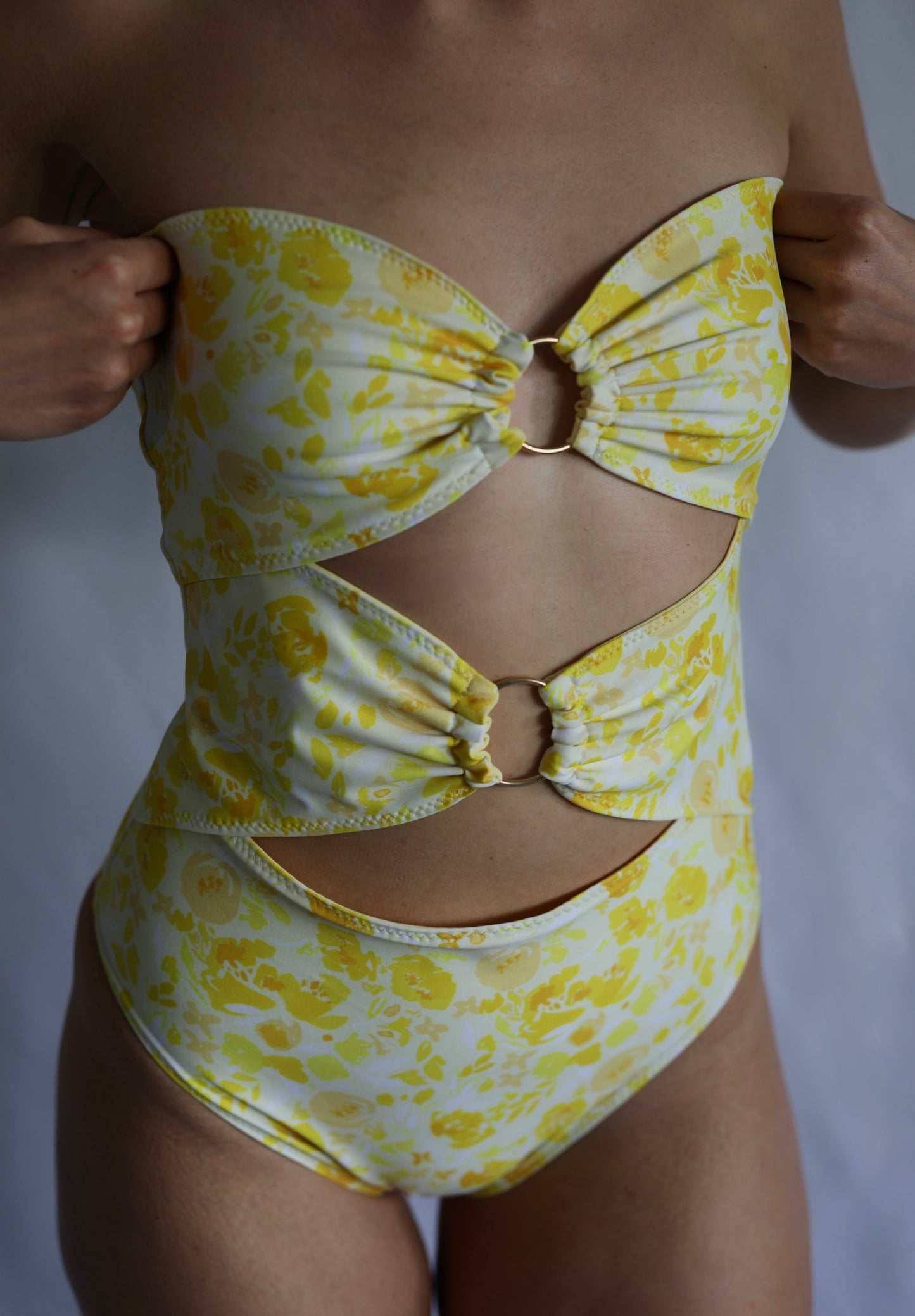 Yellow floral swimsuit on a plain background